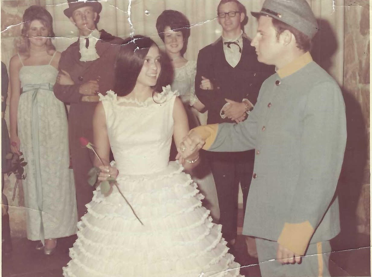 Judy and Vince holding hands at a costume party