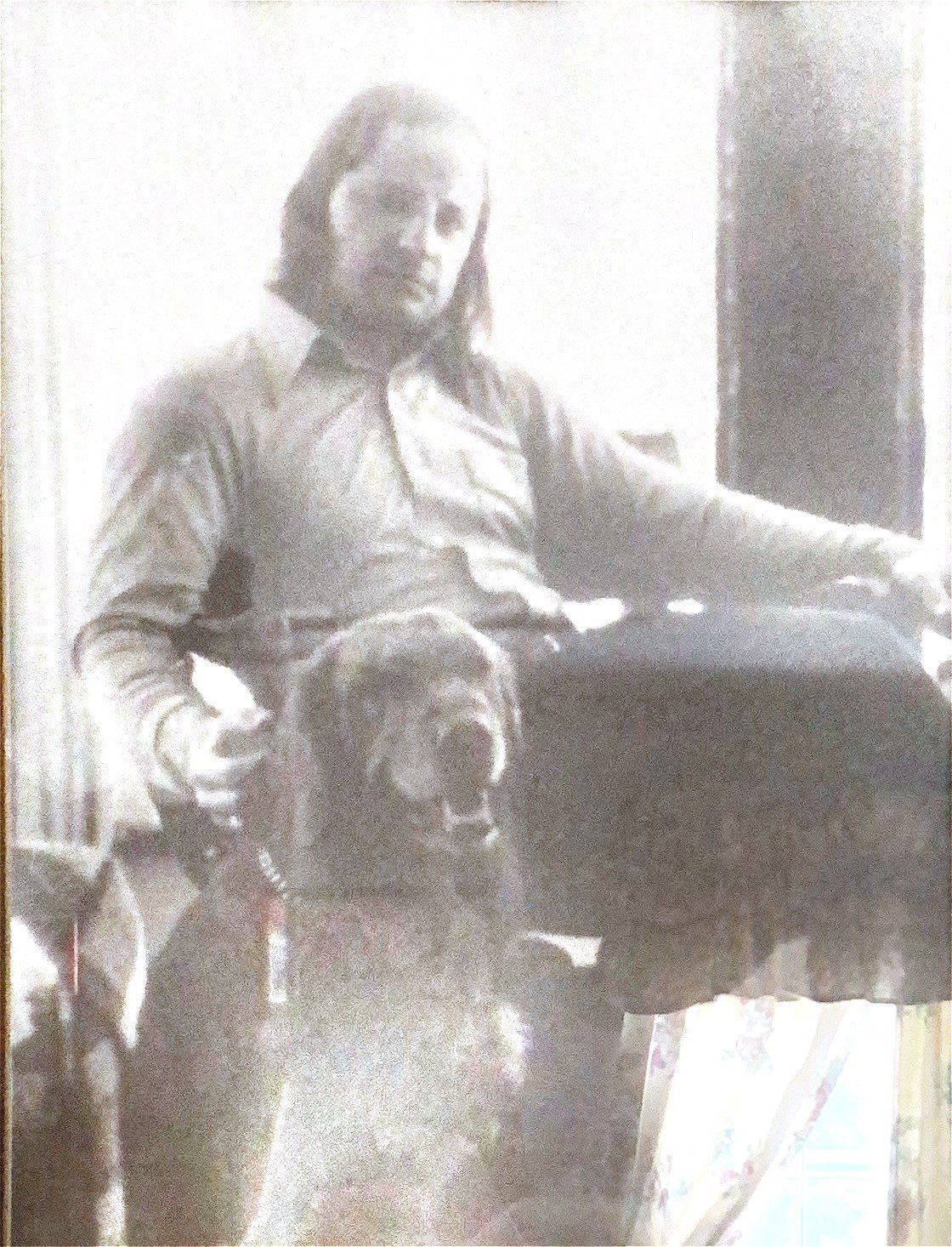 A young Vince seated near a window