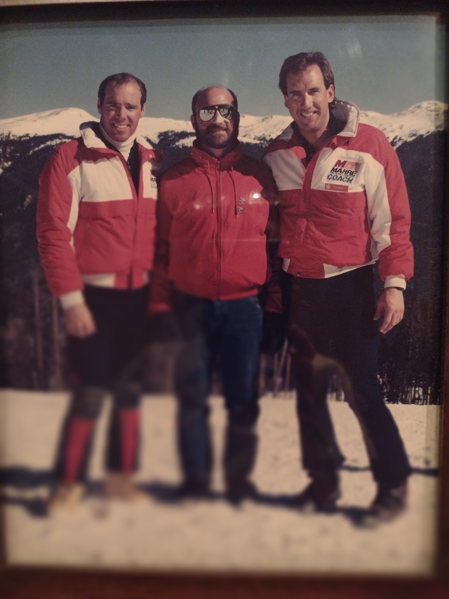 Vince standing with two fellow ski coaches in matching red jackets