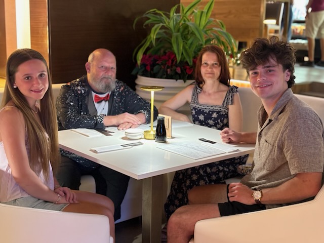 Vince and family seated together at a restaurant