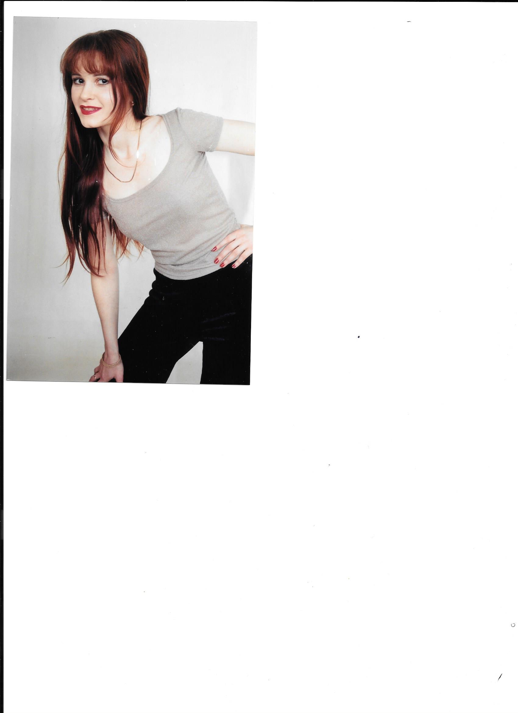 A woman posing in front of a white background